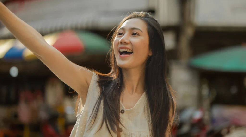 Perempuan tersenyum percaya diri dengan ketiak terbuka menandakan kenyamanan dan kulit yang sehat di area lipatan tubuh.